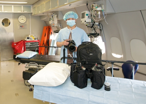 Photographer Kelvin Young on the ORBIS DC-10 Flying Eye Hospital, with Think Tank gear. 